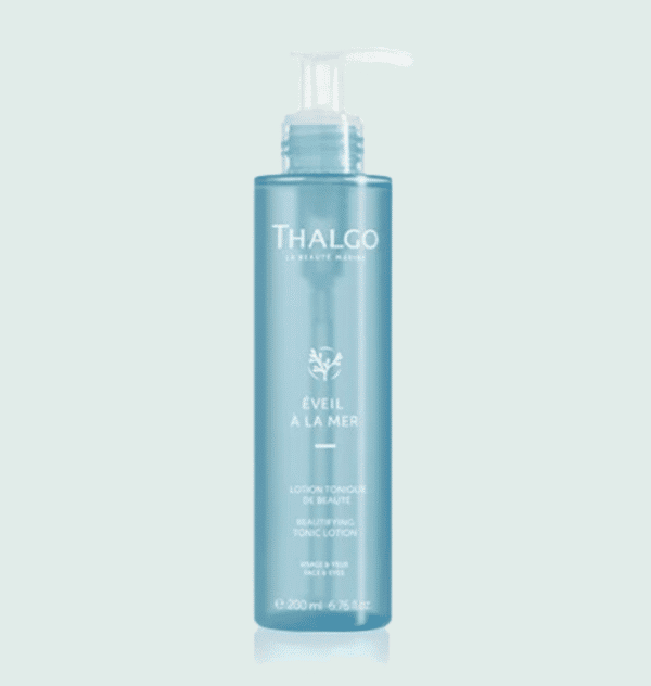 Pot de lotion tonique Thalgo, en plastique bleu transparent, avec un poussoir blanc en plastique, sur fond vert