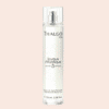 Vaporisateur de brume de soin parfumée Thalgo en verre transparent, sur fond orange